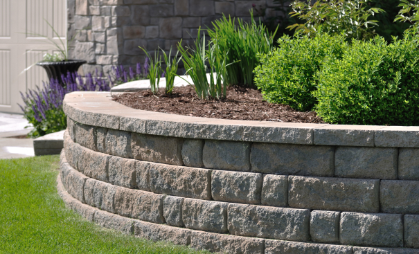 A retaining wall with carefully placed retaining wall caps adding a polished finish to the a garden landscape